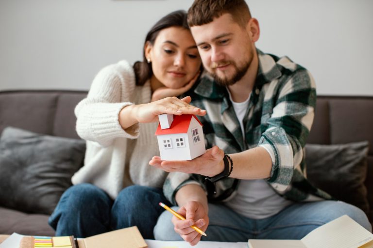 couple-holding-small-house-medium-shot (1)