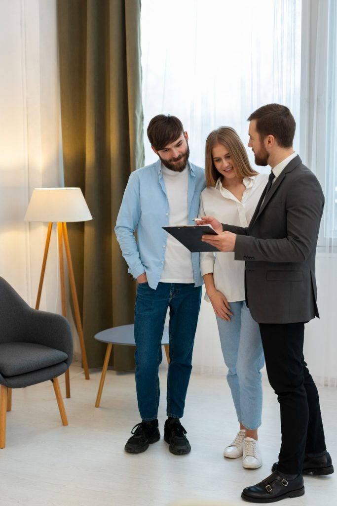 male real estate agent doing business showing house potential buying couple